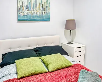 a bedroom with a bed and a lamp on a night stand at 4 BD Family Unit in Central Location in New York