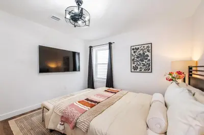 a bedroom with a bed and a flat screen tv at Apartment in Irvington Unit B in Irvington