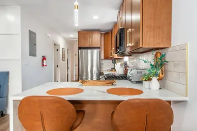 a kitchen with wooden cabinets and a white counter top at Apartment in Irvington Unit B in Irvington