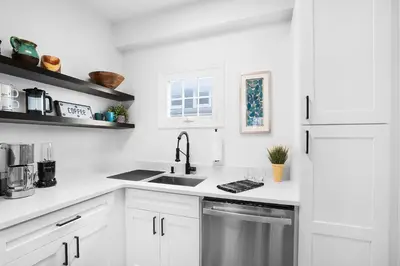 a white kitchen with a sink and a refrigerator at Montclair's Best Stays in Montclair