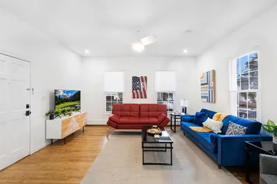 a living room with a blue couch and a red chair at Montclair's Best Stays in Montclair