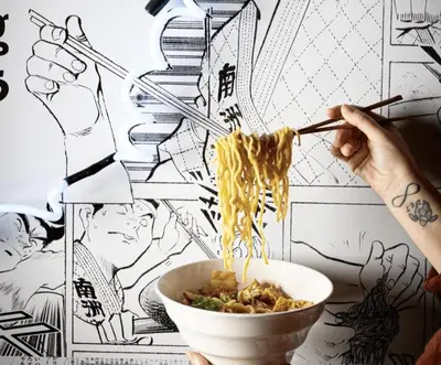 a person eating a bowl of noodles with chopsticks at Montclair's Best Stays in Montclair