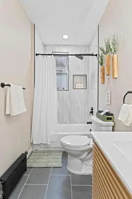 a white bathroom with a toilet and a shower at Casa Kanso in Jersey City