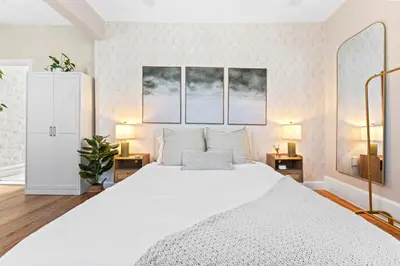 a bedroom with a large white bed with two lamps at Casa Kanso in Jersey City