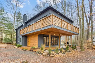 a house with a black roof and wood at Pine Breeze in Pocono Pines