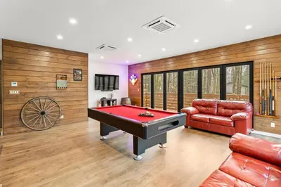 a living room with a pool table and a couch at Pine Breeze in Pocono Pines