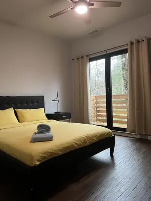 a bedroom with a bed and a large window at Pine Breeze in Pocono Pines