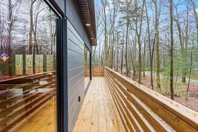 a wooden walkway leading to a building with a window at Pine Breeze in Pocono Pines