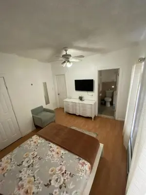 a living room with a ceiling fan and a television at Spacious Private Room with Private Bath in Paterson