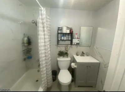 a bathroom with a toilet and a sink and a shower at Spacious Private Room with Private Bath in Paterson