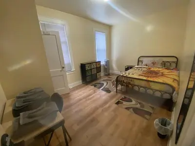 a bedroom with a bed and a wooden floor at Vibrant home all to yourself in Newark