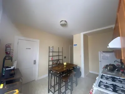 a small kitchen with a table and a refrigerator at Vibrant home all to yourself in Newark