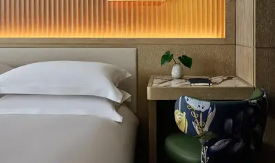 a bedroom with a bed and a table and a chair at Kimpton Era Midtown New York by IHG in New York
