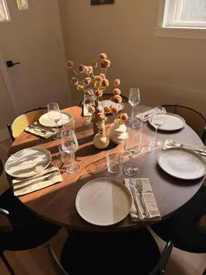 a wooden table with plates and wine glasses on it at Modern 3-Bedroom Retreat with Fire Pit - Ski at Big Bear - Mountain Views in Eldred