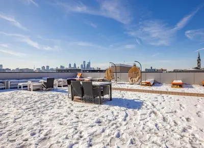 a patio with a table and chairs on a roof at Sky-view 2BD Apartment In Northern Liberties in Philadelphia
