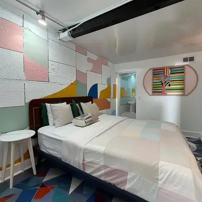a bedroom with a large bed and a colorful wall at The Helton Suites at Midtown in New York