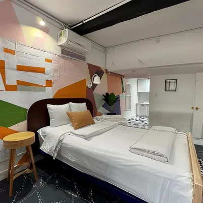 a bedroom with a large white bed with a stool at The Helton Suites at Midtown in New York
