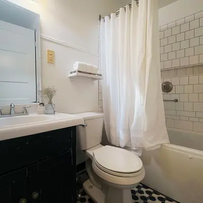 a white bathroom with a toilet and a sink at The Helton Suites at Midtown in New York