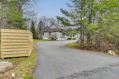 a house with a gate on the side of a road at Hot Tub and Epic Game Room! Poconos Family Retreat in Blakeslee
