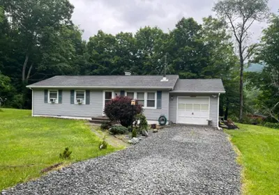 a small house with a driveway in a yard at Delaware River Retreat