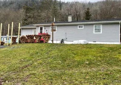 a house with a truck parked in front of a yard at Delaware River Retreat