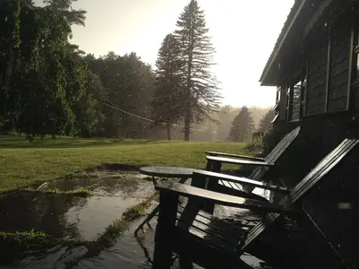 a picnic table and bench next to a house at Apple Orchard & Forest Retreat with Woodland Pond in Forestburgh