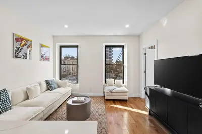 a living room with a couch and a flat screen tv at Carroll Place II - Bright 3BR Carroll Gardens Apt in Brooklyn