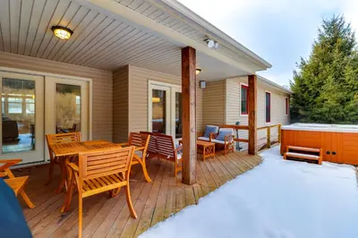a deck with a table and chairs on a house at Walk to Big Boulder Mtn and Lake, Home with Hot Tub! in Lake Harmony