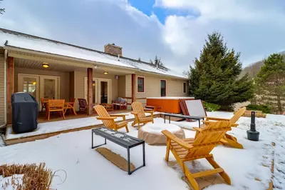 a patio with chairs and a table in the snow at Walk to Big Boulder Mtn and Lake, Home with Hot Tub! in Lake Harmony