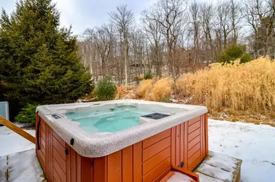 a jacuzzi tub in a snow covered yard at Walk to Big Boulder Mtn and Lake, Home with Hot Tub! in Lake Harmony