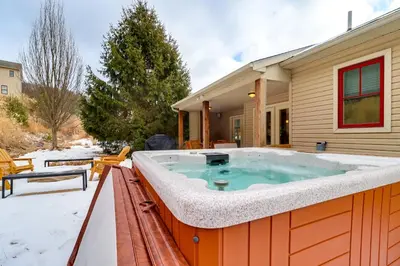 a hot tub on the back of a house in the snow at Walk to Big Boulder Mtn and Lake, Home with Hot Tub! in Lake Harmony