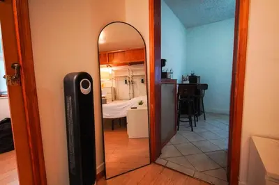 a mirror in a room with a bedroom at Private Studio Near NYC - Easy Commute & Workspace in Guttenberg