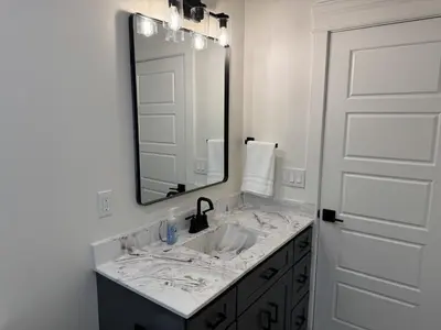 a bathroom with a sink and a large mirror at Farm Views - 10 min to Sight & Sound in Ronks