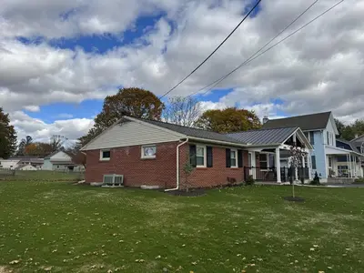 a red brick house with a green yard at Farm Views - 10 min to Sight & Sound in Ronks
