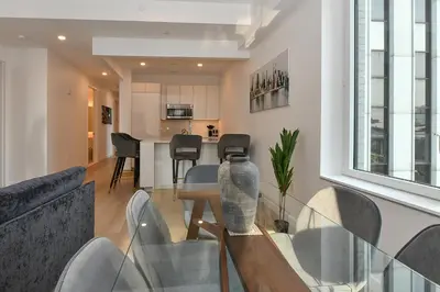 a dining room and kitchen with a glass table and chairs at Contemporary Luxury 3BR 2BA Downtown NYC in New York