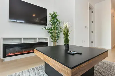 a living room with a table and a fireplace at Contemporary Luxury 3BR 2BA Downtown NYC in New York