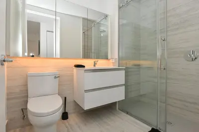 a bathroom with a toilet and a glass shower at Contemporary Luxury 3BR 2BA Downtown NYC in New York