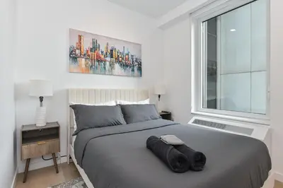 a bedroom with a large bed with a large window at Contemporary Luxury 3BR 2BA Downtown NYC in New York
