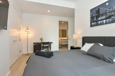 a bedroom with a bed with a bag on the floor at Contemporary Luxury 3BR 2BA Downtown NYC in New York