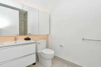 a bathroom with a toilet and a sink and a mirror at Contemporary Luxury 3BR 2BA Downtown NYC in New York