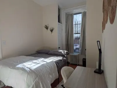 a bedroom with two beds and a table and a window at The Midtown Sanctuary - Private Silent Suite at Times Square in New York