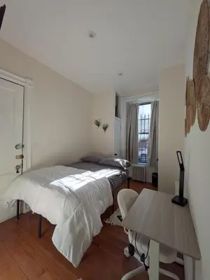 a white bedroom with a bed and a table at The Midtown Sanctuary - Private Silent Suite at Times Square in New York