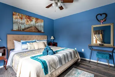a blue bedroom with a bed and a piano at Summit Retreat Hot Tub Game Room Sauna in Tobyhanna