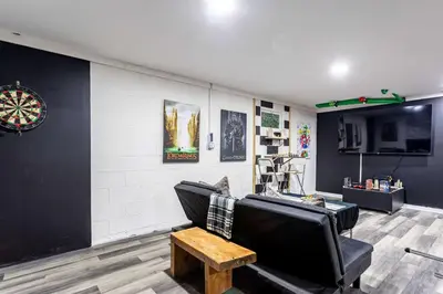 a living room with a couch and a dartboard on the wall at Summit Retreat Hot Tub Game Room Sauna in Tobyhanna