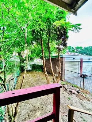 a red bench in front of a yard with trees at Very cozy 3 bedroom house close to everything in Chester