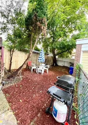 a backyard with a grill and a table and chairs at Very cozy 3 bedroom house close to everything in Chester