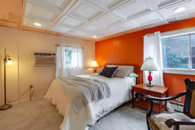 a bedroom with orange walls and a bed and a window at Mtn-View Balcony! All-Season Apt Near Jim Thorpe in Nesquehoning