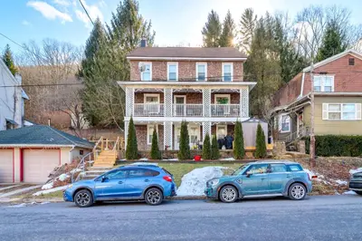 two cars parked in front of a house at Mtn-View Balcony! All-Season Apt Near Jim Thorpe in Nesquehoning