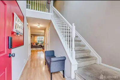 a stairway with a blue chair and a red door at Comfortable Private Room with Bath Easy Transit in Piscataway