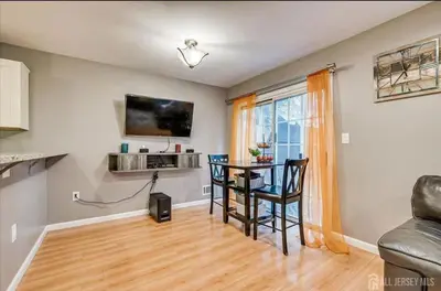 a living room with a table and chairs and a television at Comfortable Private Room with Bath Easy Transit in Piscataway